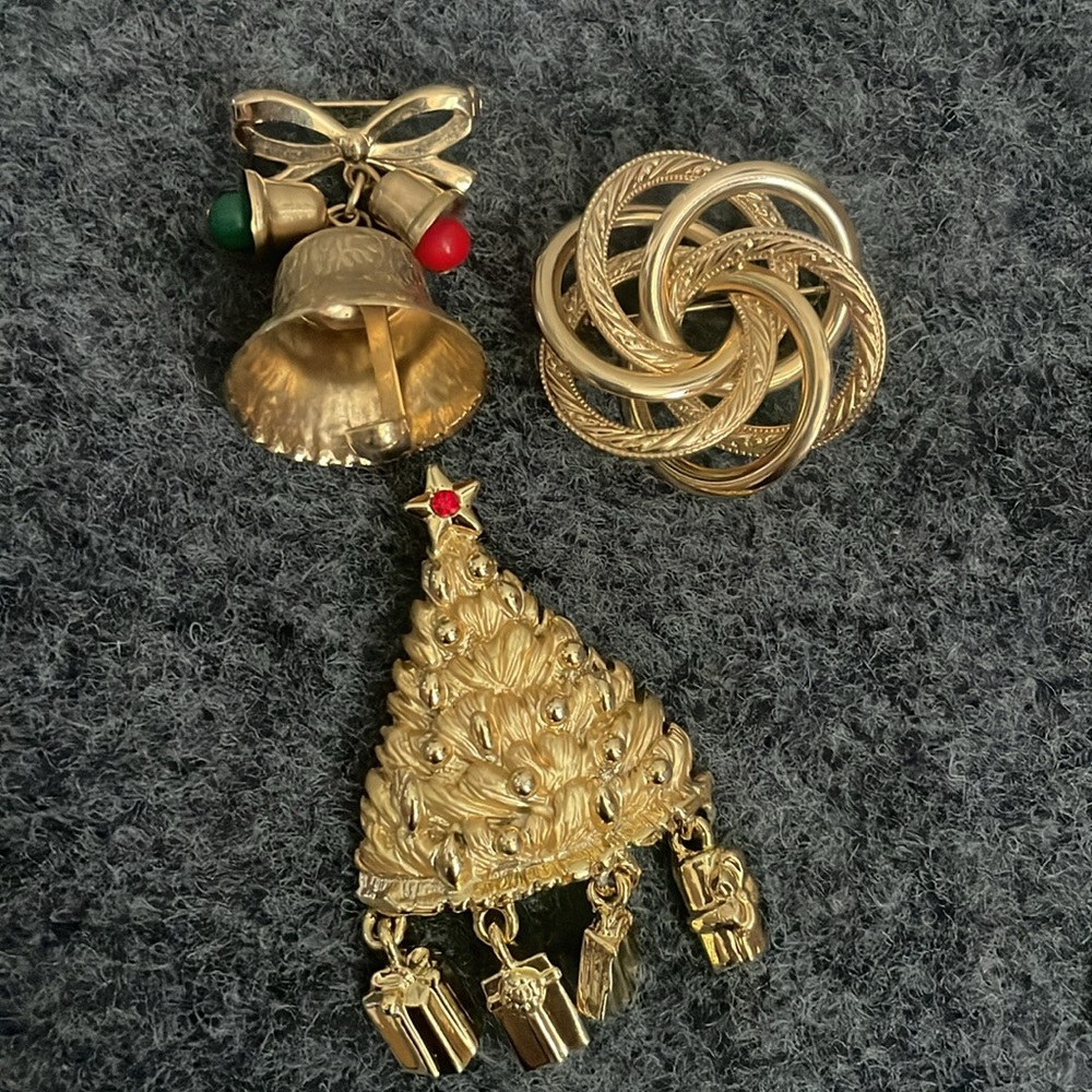 three gold-tone brooches